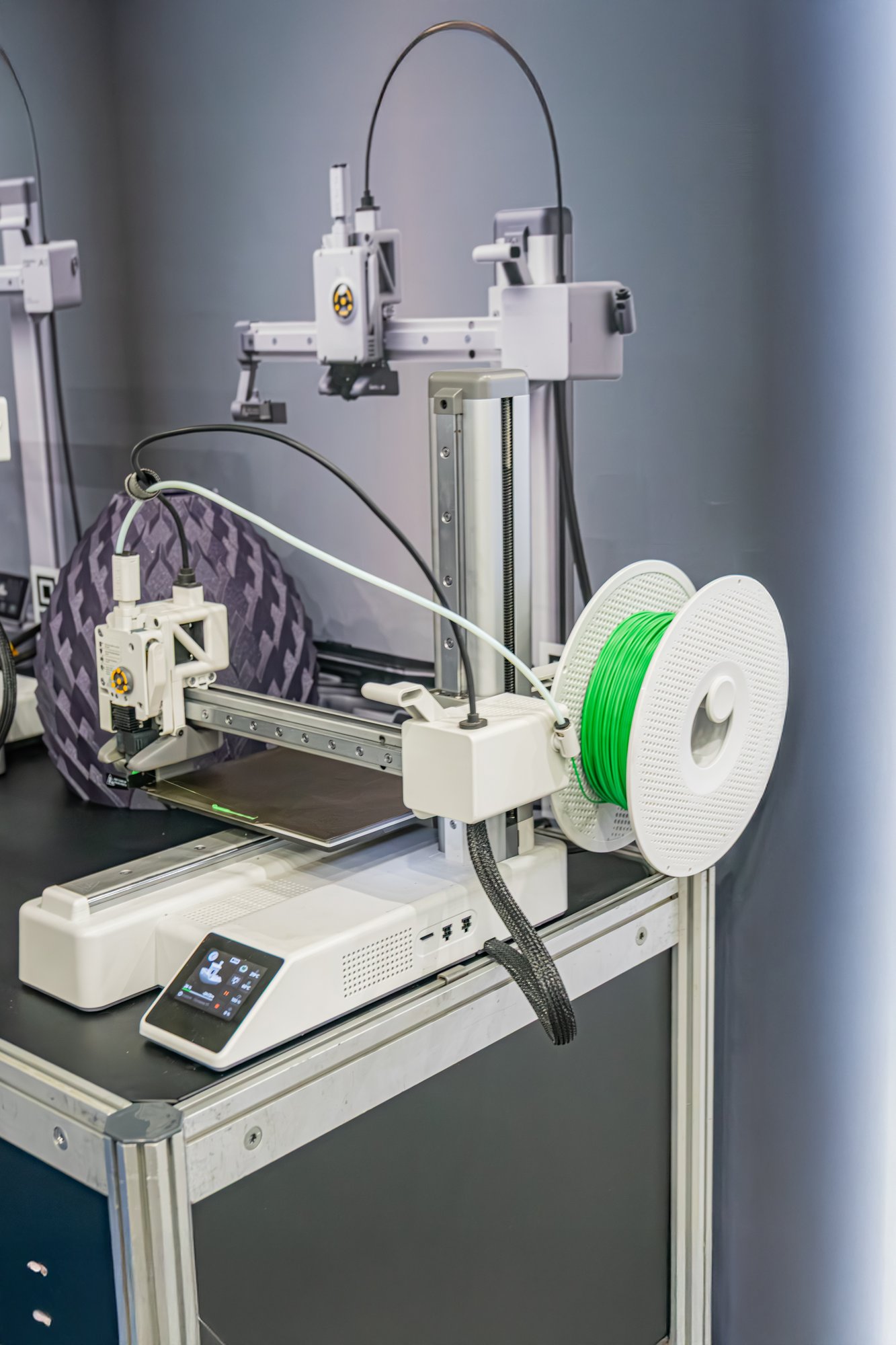 Impressora 3D de mesa carregada com bobina de filamento verde