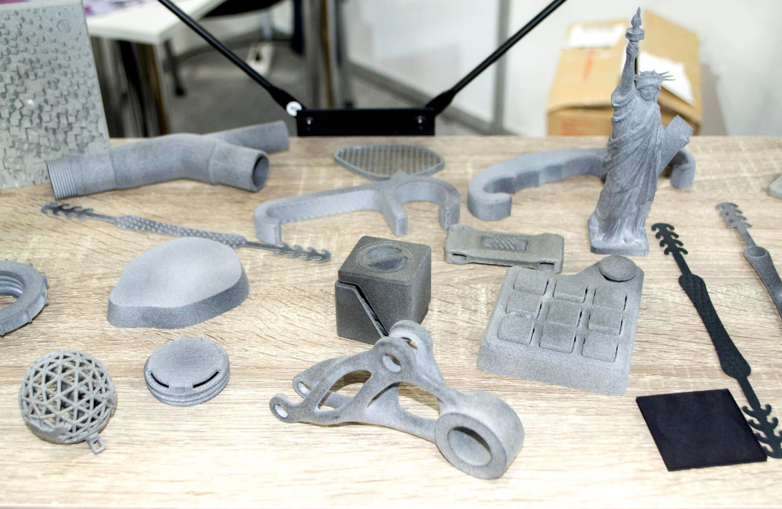 Peças impressas em 3D sobre uma mesa de madeira — imagem ilustrativa